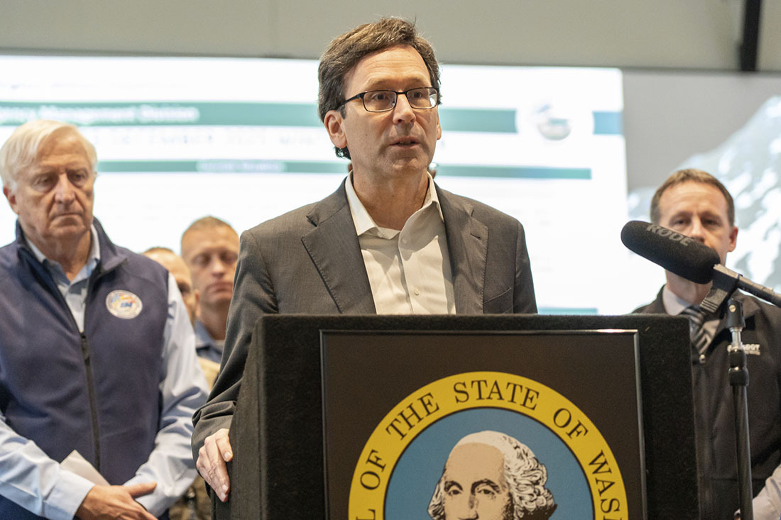 Governor Bob Ferguson speaks at a podium at the State Emergency Operations Center