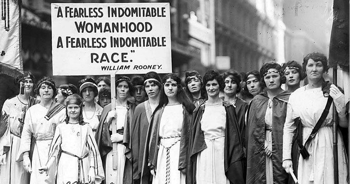 Historical photo of 20 women suffragettes gathered at an International Women's Day event in 1921. 