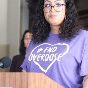 Lupe speaking at podium