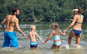 Family holding hands in lake