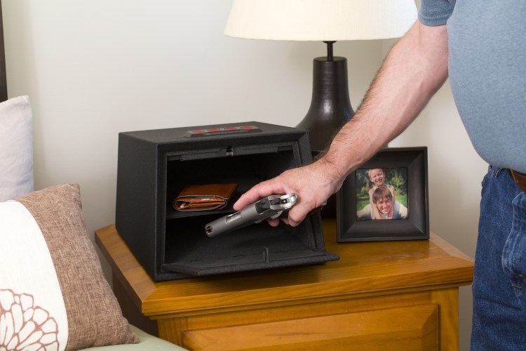 photo - hand putting gun in lockbox
