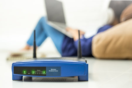 Broadband router with person using laptop in background