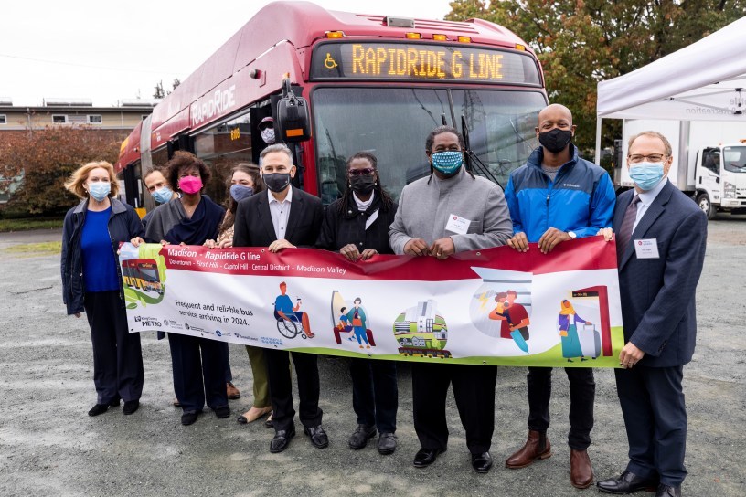 Work on RapidRide G Line is ready to start! Speakers holding the RapidRide G Line banner during the groundbreaking ceremony.