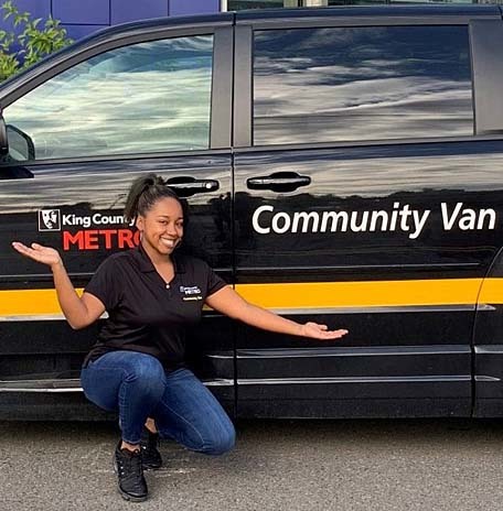 Young woman poses with van