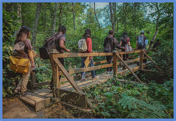 Youth Conservation Corps members crossing a bridge