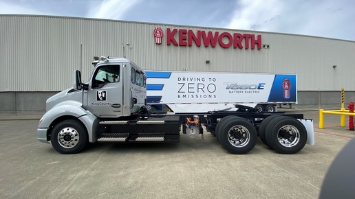 Electric truck in front of Kenmore sign in Renton. 