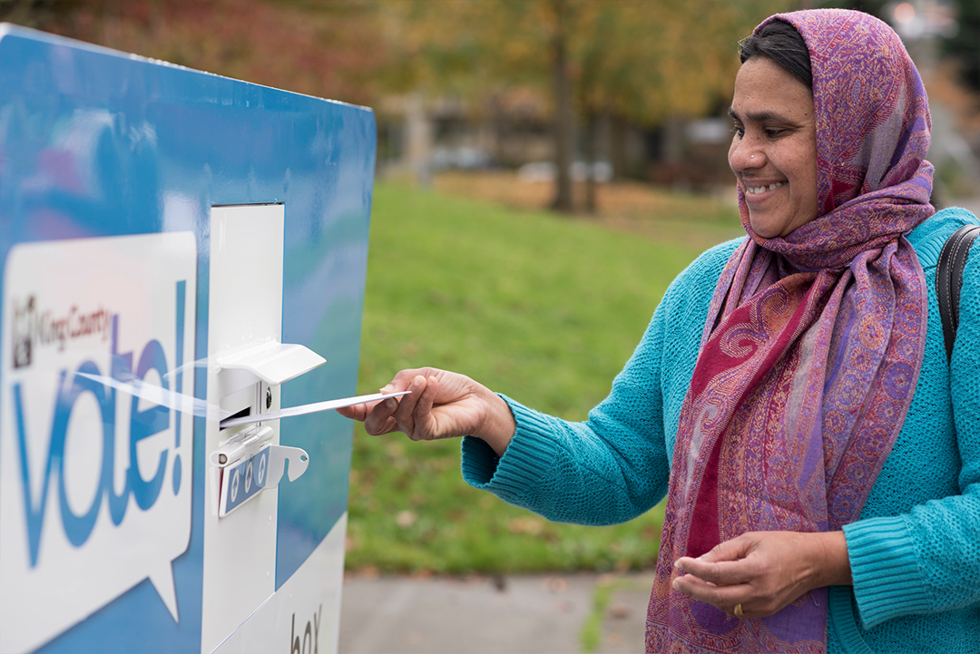 Person dropping off their ballot at a King County Elections drop box