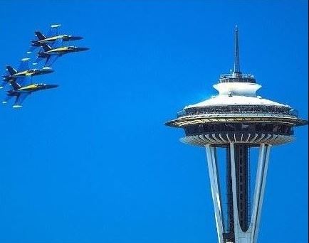 Image of 4 Blue Angel planes flying on a clear blue sky day next to the Space Needle