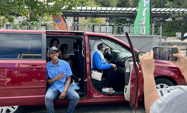 CM Zahilay and several members of the Rainier Beach Action Coalition situ in a new van as someone else takes a picture of them