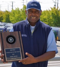 Picture of Terry Moon in Metro uniform holding his plaque recognizing him as Metro Operator of the Year 2022