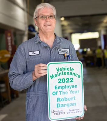 Picture of Dargan in Metro Maintenance uniform holding a sign announcing him 2022 Employee of the Year