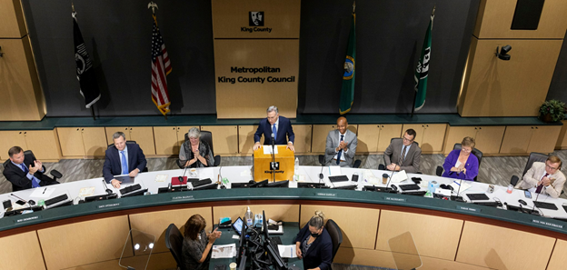 Elevated shot of the King County Council dais, where Executive Constantine is announcing his proposed biennial budget