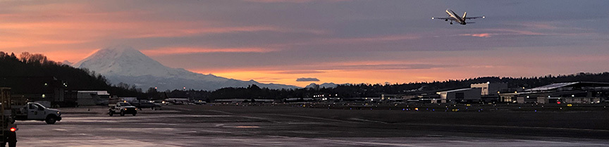 Aircraft takes off toward Mt. Rainier from King County International Airport