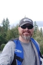Dave smiles at the photo in a Seahawks hat