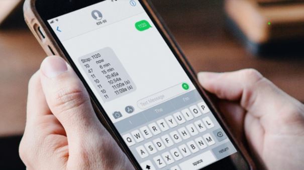 image of a person holding a phone and the screen shows the phone being used to get Text 4 Departure information 