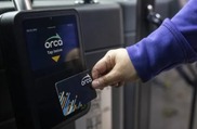 Image of a person tapping their new black ORCA card on the new ORCA reader inside the Metro bus