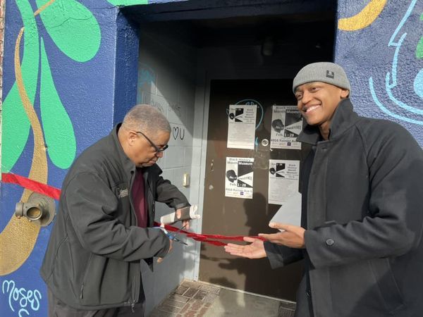 CM Larry Gossett cuts the ribbon for the new Columbia City Theater as CM Zahilay presents him 