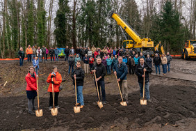 Group standing together holding shovels. 