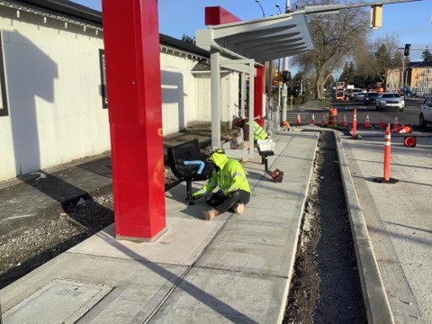 Crews installing bus shelter amenities at Ambaum Boulevard and SW 128th Street