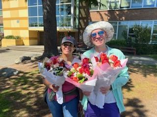 Volunteers posing with flower bouquets