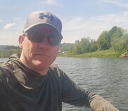 A man in a boat smiles at the camera