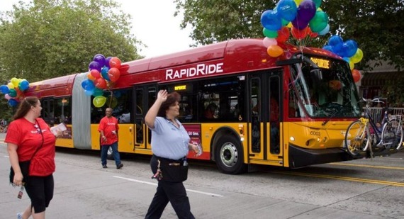 RapidRide bus driving in a parade with King County Metro employees