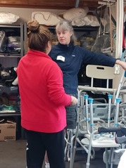 Vashon Care Network Board member, Tory Hayes (center), shows off the Care Closet's inventory of equipment.