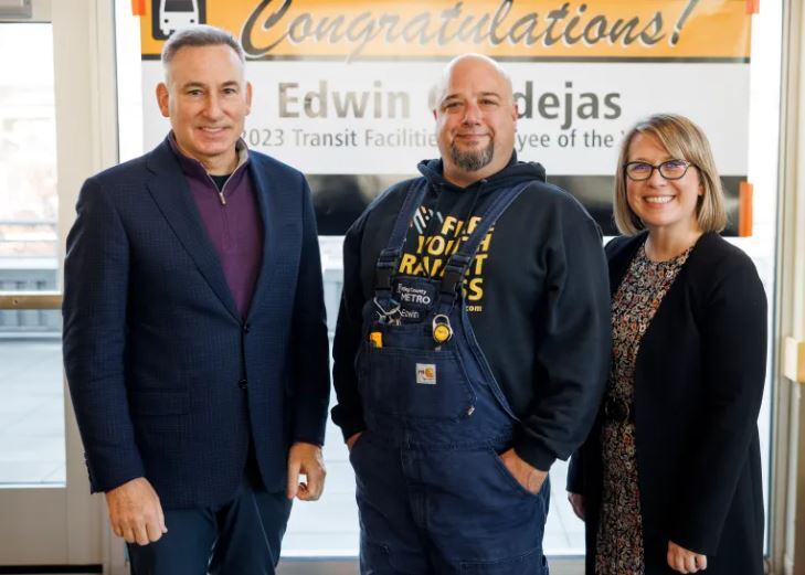 image of  Exec Dow Constantine, Edwin and GM Michelle Allison infront of banner with Edwins name