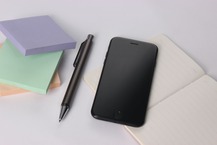 picture of cell phone, pen and sticky pads