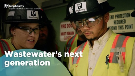 Wastewater's next generation, a group of people wearing hard hats and safety gear huddle at a worksite