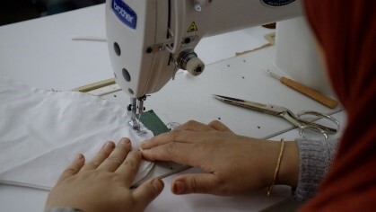 person sewing on a sewing machine