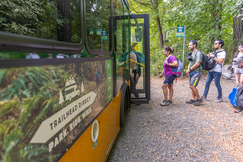 Hikers board a Trailhead Direct bus.