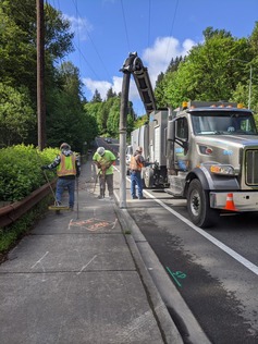 Image shows crews locating utilities using a vacuum truck.