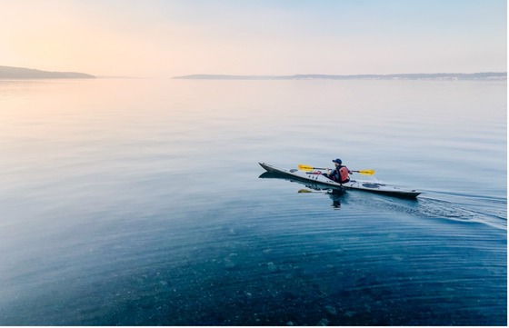 A lone kayaker takes a sunset paddle in Puget Sound. 