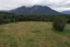 Open grass meadow with clouds and mountain