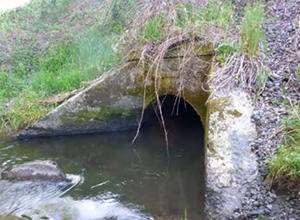 Close up photo of a culvert with water