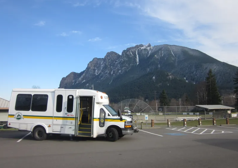 SVT bus parked in front of mountain and baseball feild