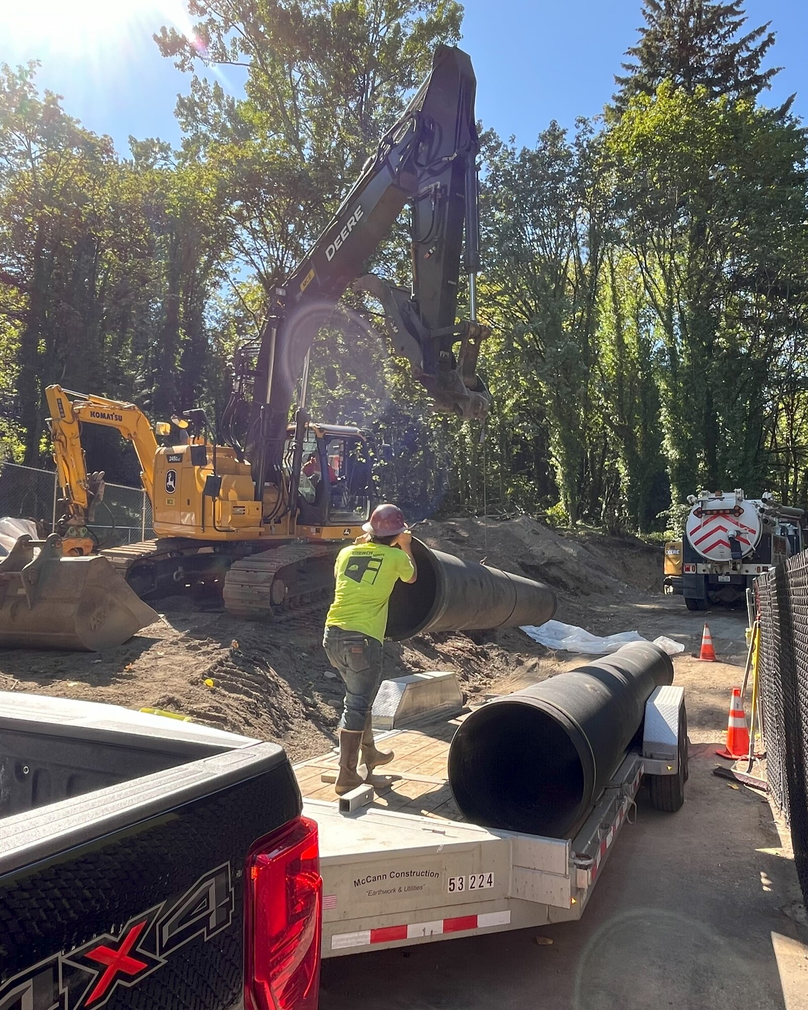 Construction worker delivers a pipe segment to the construction site using a construction vehicle