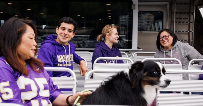 Husky fans pictured in football jerseys ride the King County Water Taxi into town