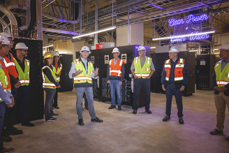 Project staff gather under the neon lights celebrating clean power and clean water