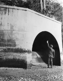  A man stands in front of the 12-foot diameter terminus of the old Fort Lawton Tunnel. 