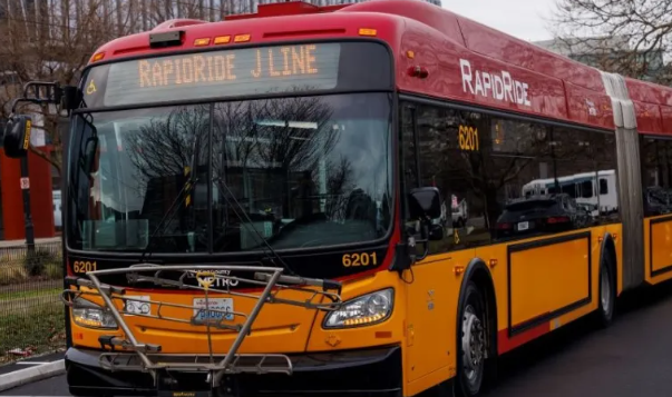 Image of a red and gold articulated bus with RapidRide J Line on the destination sign 