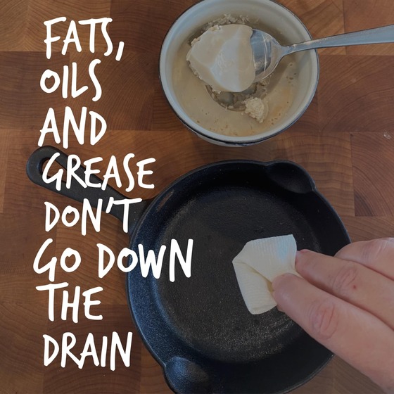 Hand wipes grease from a skillet with a paper towel near a bowl of solid fats. Text reads, 'Fats, oils, and grease don't go down the drain.'