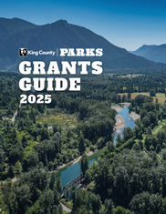 Drone photo of Mount Si and a river in North Bend. Over the photo are the words King County Parks Grant Guide 2025