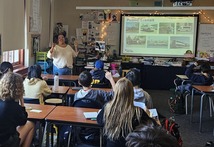 Adult standing in front of class of students