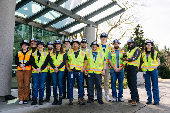 A group of Operator-in-Training program participants wearing safety vests and hard hats pose for a photo outside South Treatment Plant.