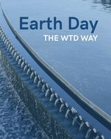 Water flows over a treatment tank weir with the text “Earth Day the WTD Way” above.