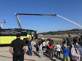 Fire truck spraying water with visitors watching