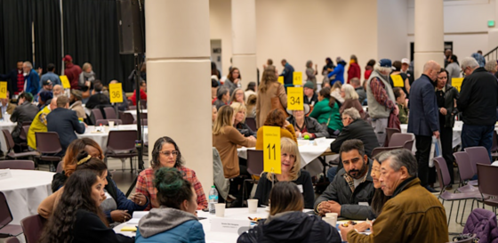 A photo of people sitting around tables in an event hall during a previous Behavioral Health Forum