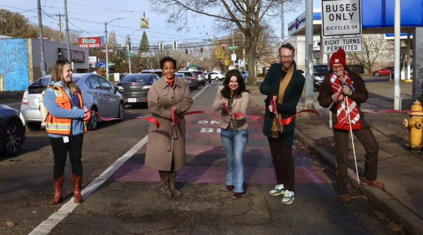 image of of ribbon cutting on the bus lane on Rainier Ave with 5 people in the bus lane